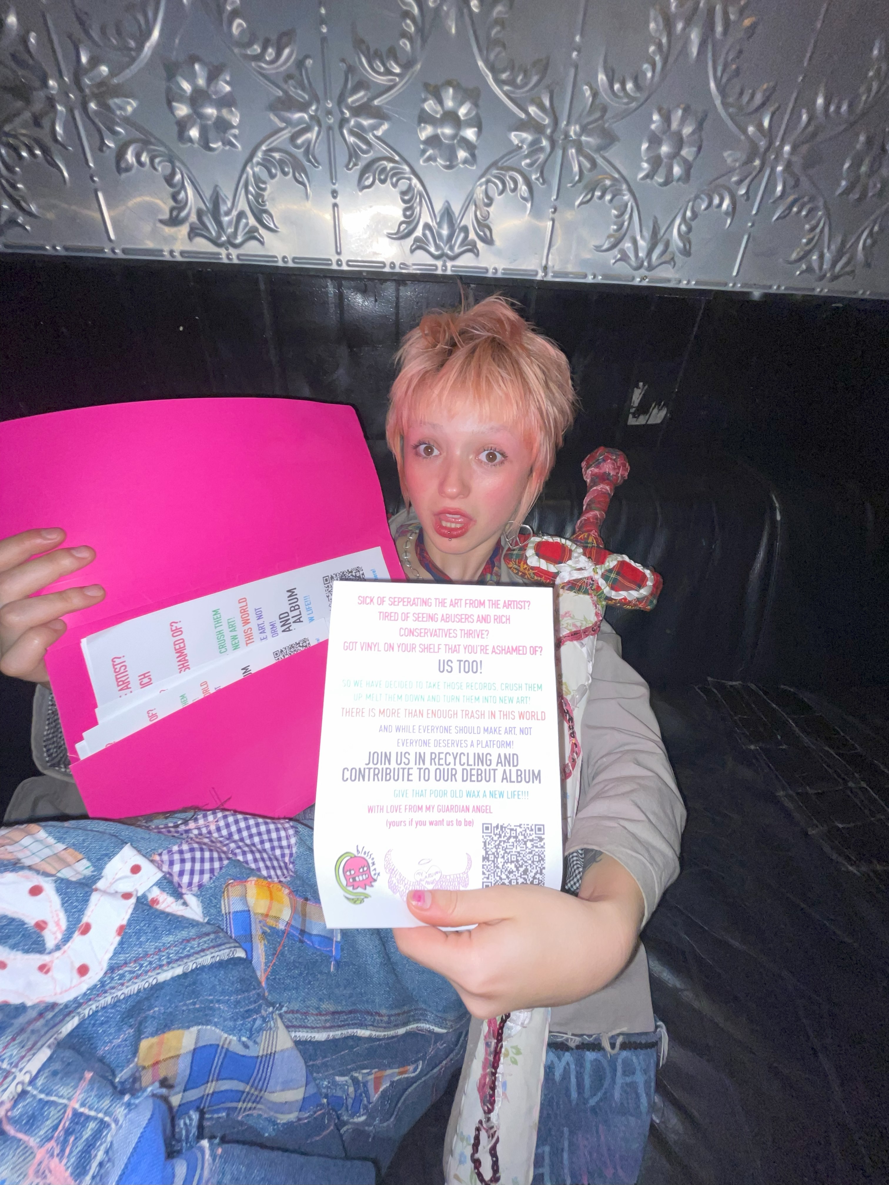 photo of Ada at The Last Chance Rock and Roll bar holding the flyer for our vinyl recyclng scheme.