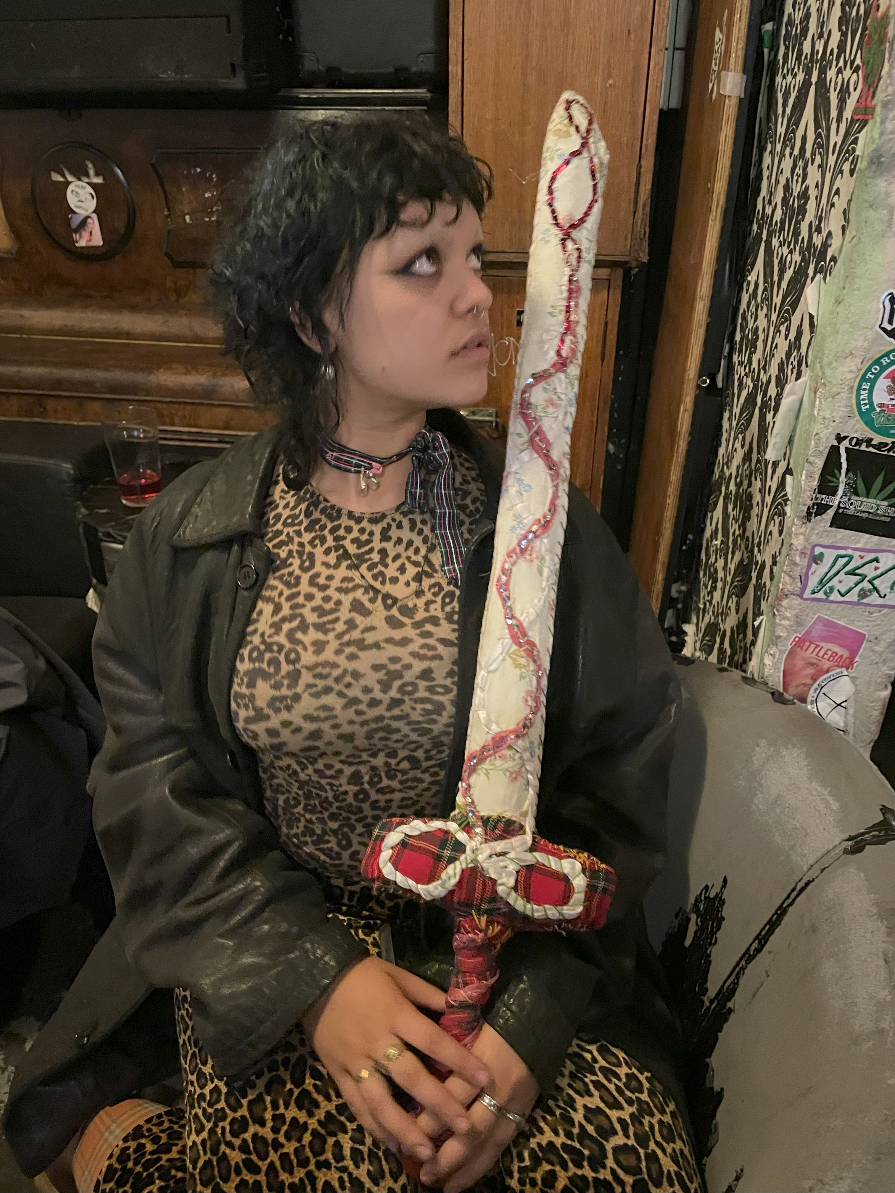 photo of Florence at The Last Chance Rock and Roll Bar in full leopard print holding a soft sculpture sword made by Ada.